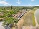 Aerial view of townhouses showcasing beautiful tree coverage, and a serene lake at 5559 Brassy Loop, North Port, FL 34287