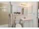 Bright bathroom featuring tiled shower, white vanity, mirrored cabinet, and modern lighting fixture at 5559 Brassy Loop, North Port, FL 34287