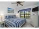 Bright bedroom with white furniture, blue accents, a large window and light, wood-look flooring at 5559 Brassy Loop, North Port, FL 34287