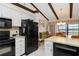 Bright kitchen with stainless appliances, white cabinetry, breakfast bar, and dining area with beamed ceiling at 5559 Brassy Loop, North Port, FL 34287