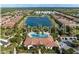Overhead view of a community featuring a pool, a tranquil lake, and well-maintained grounds, creating a serene environment at 5581 Piccolo St, Nokomis, FL 34275