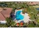 Aerial view of a beautiful community pool featuring tropical landscaping, lounge seating, and umbrellas for relaxation at 5581 Piccolo St, Nokomis, FL 34275