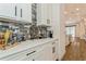 A stylish bar area features stone backsplash, white countertops, and sleek cabinetry at 5581 Piccolo St, Nokomis, FL 34275