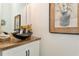 The bathroom has a wood countertop, an interesting sink, a stylish mirror, and unique art at 5581 Piccolo St, Nokomis, FL 34275