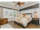 Charming bedroom with shiplap accent wall, wood beams, and modern lighting creating a cozy atmosphere at 5581 Piccolo St, Nokomis, FL 34275