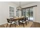 A modern dining room features a wooden table, stylish chairs, and views of the pool at 5581 Piccolo St, Nokomis, FL 34275