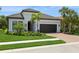 Beautiful single Gathering home with a tile roof, paver driveway, manicured lawn and tropical landscaping at 5581 Piccolo St, Nokomis, FL 34275
