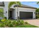 Close up of home exterior showcasing the landscaped lawn and beautiful paver driveway at 5581 Piccolo St, Nokomis, FL 34275
