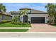 Beautiful single Gathering home with a tile roof, paver driveway, manicured lawn and tropical landscaping at 5581 Piccolo St, Nokomis, FL 34275
