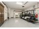 A spacious garage features a golf cart, custom storage cabinets, and epoxy flooring at 5581 Piccolo St, Nokomis, FL 34275
