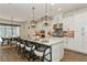 Bright, modern kitchen with white cabinets, a large island with seating and stainless steel appliances at 5581 Piccolo St, Nokomis, FL 34275