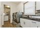 Functional laundry room with modern washer and dryer, stylish cabinets, and convenient sink area at 5581 Piccolo St, Nokomis, FL 34275