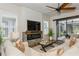 Living room with comfortable seating, electric fireplace, ceiling fan and sliding glass doors at 5581 Piccolo St, Nokomis, FL 34275