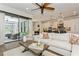 Living room with a large sofa, ceiling fan and sliding glass doors to the outside at 5581 Piccolo St, Nokomis, FL 34275
