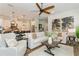 Open concept living room with modern decor, ceiling fan, and adjacent kitchen and dining areas at 5581 Piccolo St, Nokomis, FL 34275