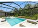 Beautiful screened pool with in-pool loungers, basketball hoop, and lush landscaping offers a private outdoor oasis at 5581 Piccolo St, Nokomis, FL 34275