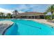 Resort-style pool with ample seating and umbrellas, surrounded by lush landscaping and palm trees at 5581 Piccolo St, Nokomis, FL 34275