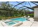 An inviting pool and spa are surrounded by a screened enclosure and beautiful landscaping at 5581 Piccolo St, Nokomis, FL 34275