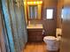 Bathroom featuring a single-sink vanity, mirrored medicine cabinet, toilet, and shower with patterned curtain at 5668 Holiday Park Blvd, North Port, FL 34287