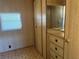 A bedroom featuring a small window and a built-in wardrobe with multiple drawers over carpeted floor at 5668 Holiday Park Blvd, North Port, FL 34287