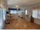 Open-concept living and kitchen area with wood floors, white walls, and natural light from curtained windows at 5668 Holiday Park Blvd, North Port, FL 34287