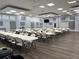 Large meeting room featuring rows of tables and chairs, ample lighting, and wood-look flooring at 5668 Holiday Park Blvd, North Port, FL 34287
