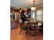 Inviting dining area with a glass top table, wooden chairs, and an elegant chandelier, adjacent to the kitchen at 603 Leisure, Venice, FL 34285