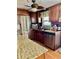 Well-lit kitchen featuring stainless steel appliances, granite countertops, dark wood cabinetry, and a mosaic backsplash at 603 Leisure, Venice, FL 34285