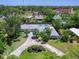 Aerial view of a property with a spacious backyard, pool, well-manicured landscaping, and circular driveway at 607 Bay Point Ave, Nokomis, FL 34275