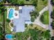 Aerial view showcasing a home with two pools, manicured lawns, patios, and landscaping, creating an outdoor oasis at 607 Bay Point Ave, Nokomis, FL 34275