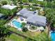 Aerial view of property featuring a spacious backyard, a large pool, and plenty of outdoor seating areas at 607 Bay Point Ave, Nokomis, FL 34275