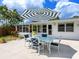 Outdoor seating with the patio umbrella, a great place to entertain while enjoying the beautiful yard at 607 Bay Point Ave, Nokomis, FL 34275