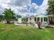 Expansive backyard featuring lush lawn, inviting patio, tropical plants, and potential for outdoor enjoyment at 607 Bay Point Ave, Nokomis, FL 34275