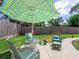 Inviting backyard patio with an umbrella, outdoor seating, and lush green lawn at 607 Bay Point Ave, Nokomis, FL 34275