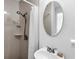 Bathroom featuring shower with neutral tile, classic fixtures, and a pedestal sink with an oval mirror at 607 Bay Point Ave, Nokomis, FL 34275