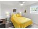 Cozy bedroom with bright, white walls and yellow comforter that fills the room with warmth at 607 Bay Point Ave, Nokomis, FL 34275