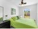 Cozy bedroom with green bedding, a ceiling fan, and a bright window offering natural light at 607 Bay Point Ave, Nokomis, FL 34275