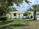 Charming home with lush greenery and a well-manicured lawn and a white exterior at 607 Bay Point Ave, Nokomis, FL 34275