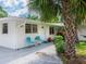 Welcoming front entrance featuring a charming door, seating, and lush landscaping, adding to the curb appeal at 607 Bay Point Ave, Nokomis, FL 34275