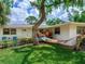 Inviting home exterior with a hammock, lush landscaping, and charming seating area, perfect for relaxation at 607 Bay Point Ave, Nokomis, FL 34275