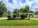 Lush front yard of home with mature landscaping, green lawn, and circular driveway at 607 Bay Point Ave, Nokomis, FL 34275