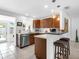 Kitchen featuring breakfast bar, stainless appliances, wood cabinets, and a bright, airy atmosphere at 607 Bay Point Ave, Nokomis, FL 34275