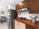 Modern kitchen featuring stainless steel refrigerator, wood cabinets, and updated countertops at 607 Bay Point Ave, Nokomis, FL 34275