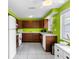 Well-lit kitchen with dark wood cabinetry, white appliances, and a window view at 607 Bay Point Ave, Nokomis, FL 34275