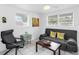 Comfortable living room featuring a gray couch, chair, and a brightly lit interior space at 607 Bay Point Ave, Nokomis, FL 34275