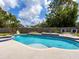 Serene backyard featuring a beautiful pool, spa, and lush landscaping, perfect for outdoor relaxation and enjoyment at 607 Bay Point Ave, Nokomis, FL 34275