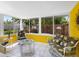 Bright sunroom featuring comfortable seating and a beautiful view of the fenced backyard at 607 Bay Point Ave, Nokomis, FL 34275