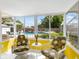 Relaxing sunroom with patterned chairs and a view of the sparkling swimming pool at 607 Bay Point Ave, Nokomis, FL 34275