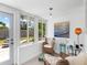 Cozy sunroom with seating, natural light, and outdoor views of a fenced yard with mature trees at 607 Bay Point Ave, Nokomis, FL 34275