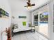 Bright sunroom with tiled floors, futon, and sliding doors that leads to the backyard pool area at 607 Bay Point Ave, Nokomis, FL 34275